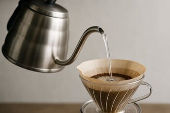 Gooseneck kettle pouring water into a dripper